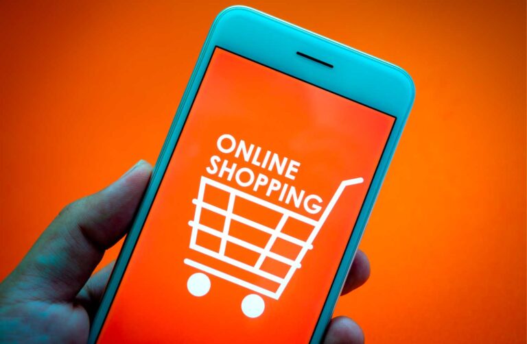 Celular azul con texto en pantalla de online shopping, lo esta sosteniendo una mano