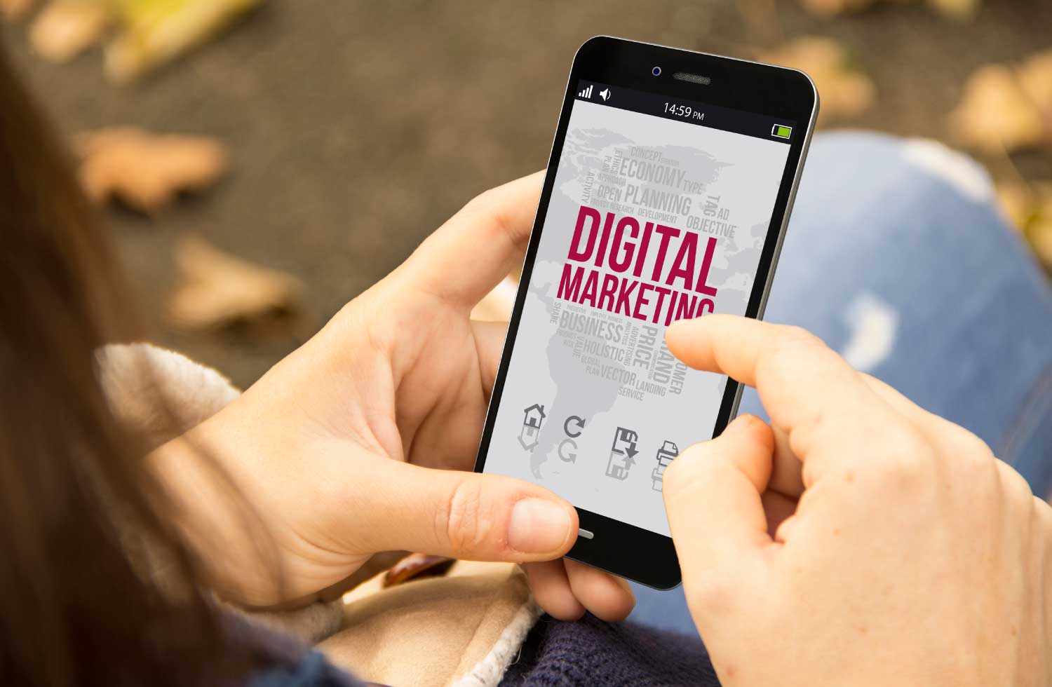 Manos que sujetan un celular con las letras digital marketing en el, representando la publicidad digital