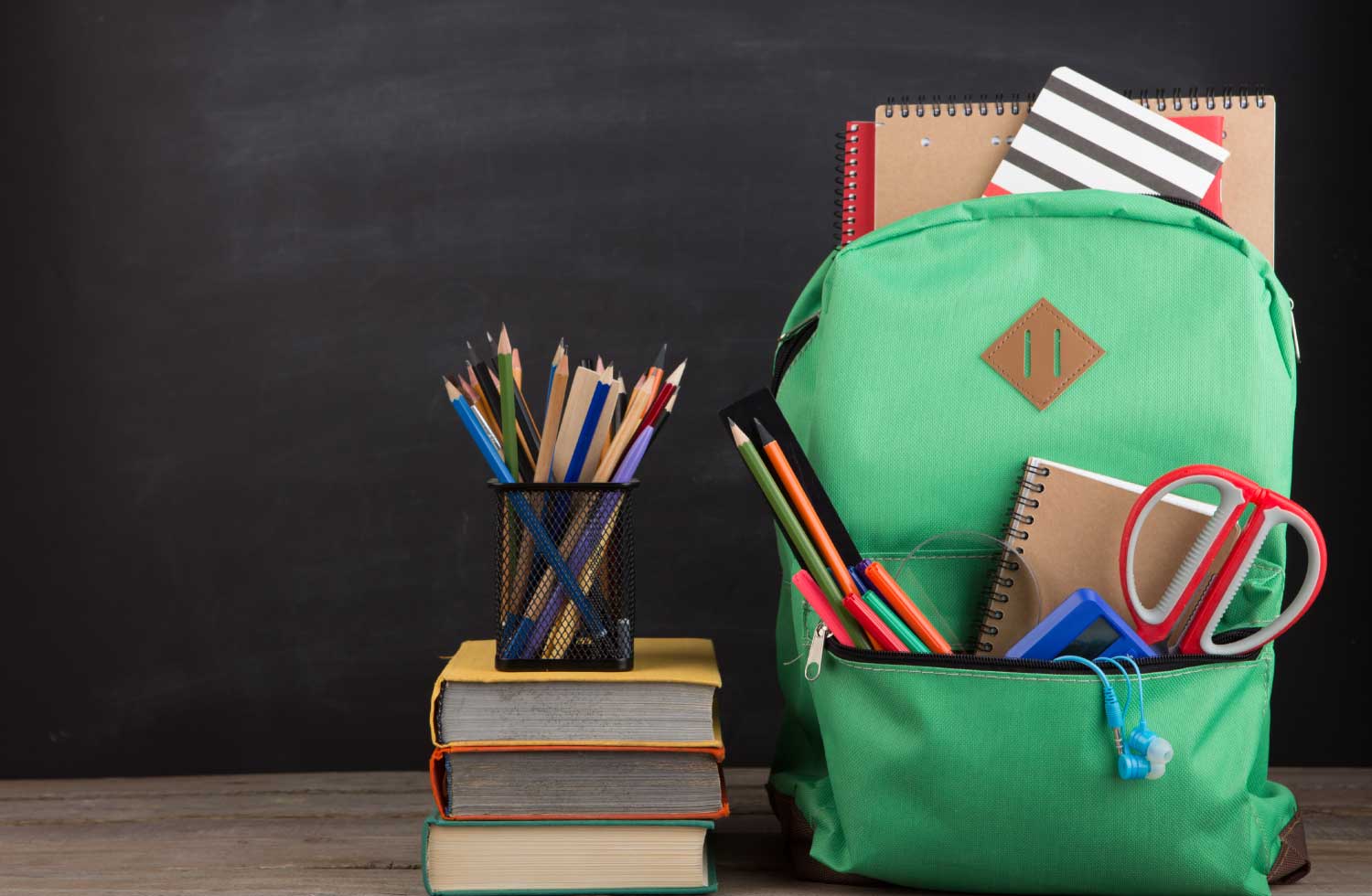 Imagen de una mochila y unos libros con utiles escolares representan el seguro educativo