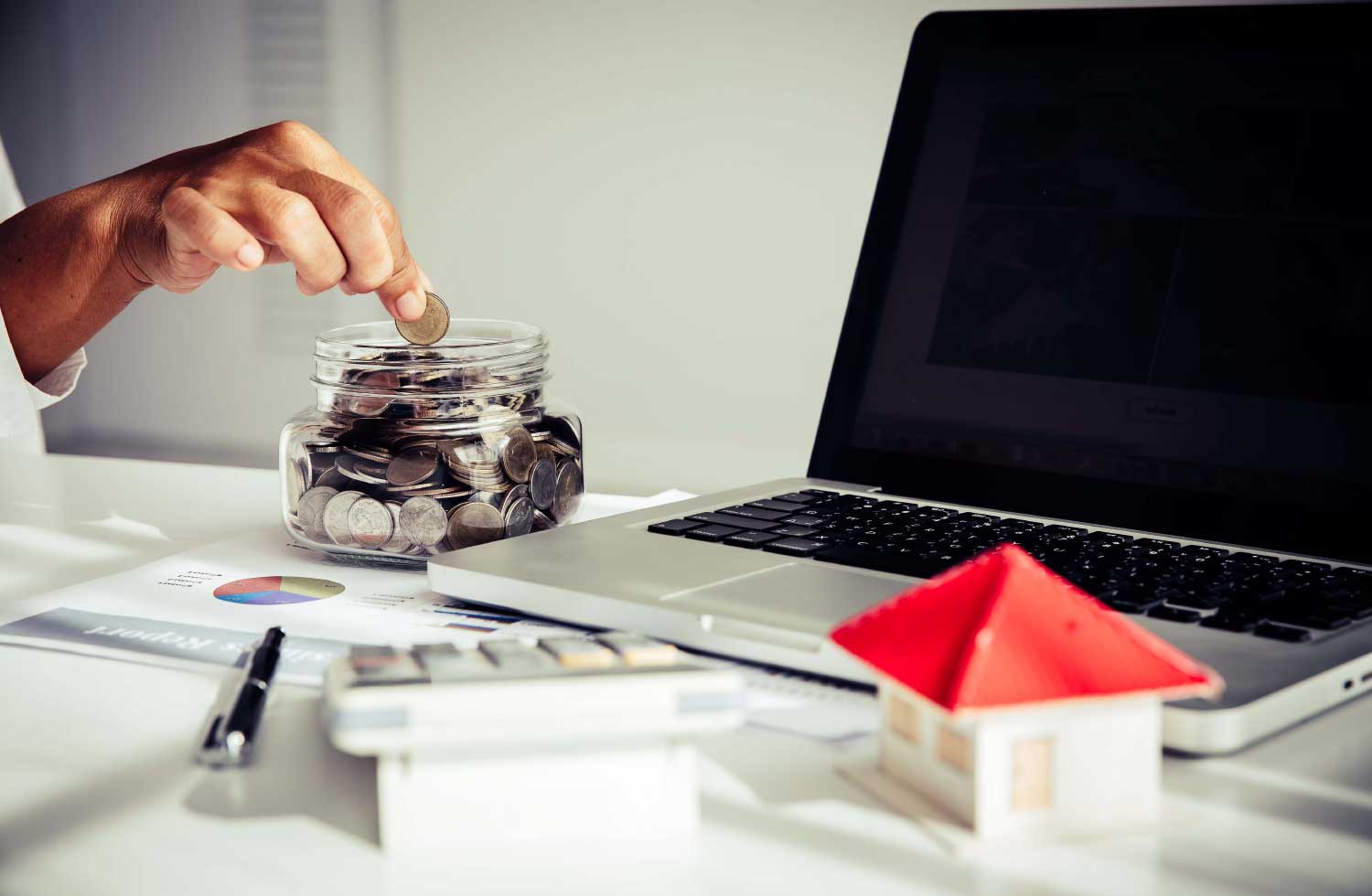 Imagen de una mano llenando un embase de vidrio con monedas representa el seguro de renta vitalicia