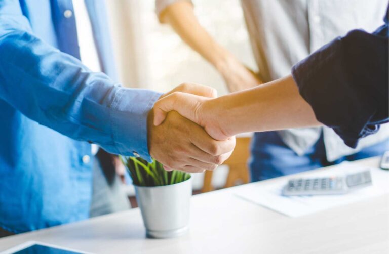 Seguro de responsabilidad civil profesional, dos personas dandose la mano en un ambiente laboral