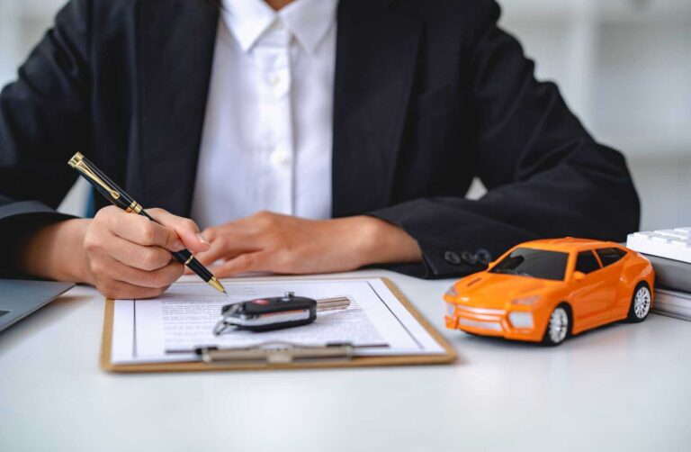 hombre con una pluma y una tabla con un contrato y un carro a escala a su lado representa el seguro de responsabilidad civil vehicular